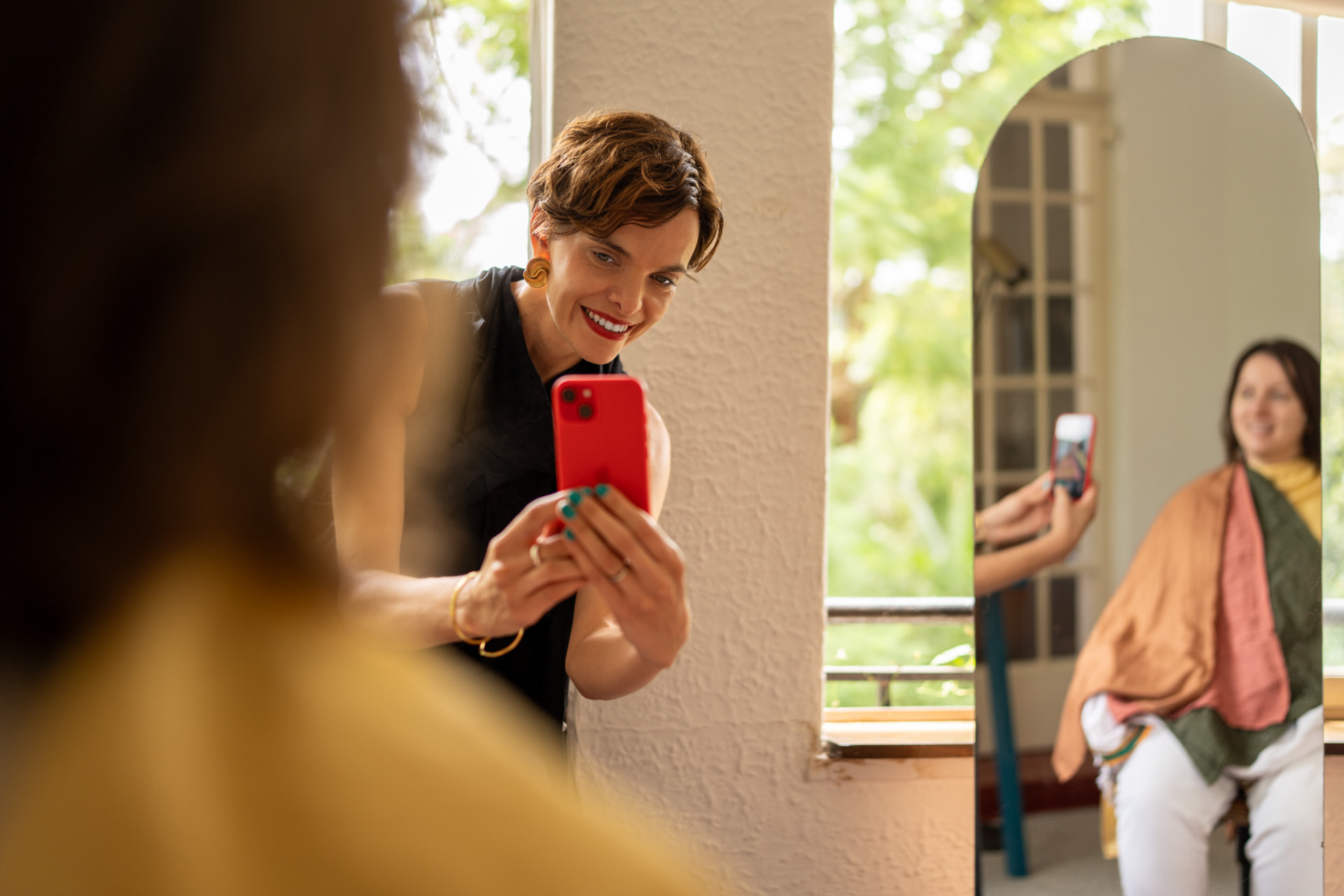 Rentia photographing a client draped in colour in front of a mirror